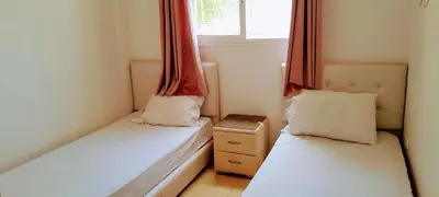 two beds in a small room with a window at Marwan's apartment 2 in Ifrane
