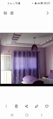 a bedroom with purple curtains and a bed at واد فاس in Douar Trhaïtia