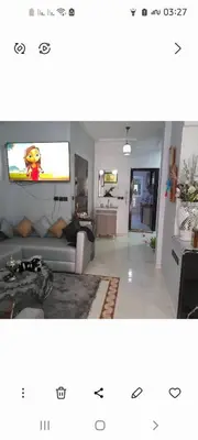 a living room with a couch and a tv on a wall at واد فاس in Douar Trhaïtia
