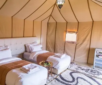 a room with two beds in a tent at Merzouga Sardegna Luxury Camp in Merzouga