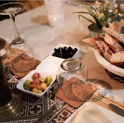 a table with a plate of bread and a bowl of fruit at Merzouga Sardegna Luxury Camp in Merzouga