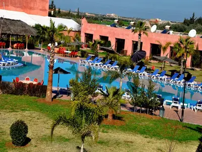 a resort with a swimming pool with lounge chairs at Hôtel Jnane Ain Asserdoune in Oulad Yaïch