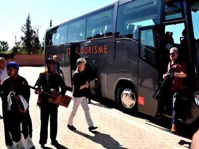 a group of people standing in front of a bus at Hôtel Jnane Ain Asserdoune in Oulad Yaïch