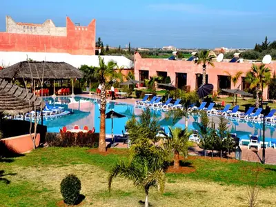 a resort with a large swimming pool with chairs at Hôtel Jnane Ain Asserdoune in Oulad Yaïch