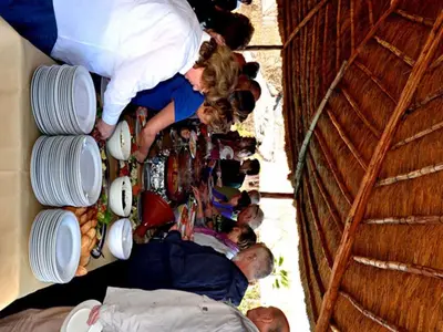 a group of people standing next to a wall with dishes at Hôtel Jnane Ain Asserdoune in Oulad Yaïch