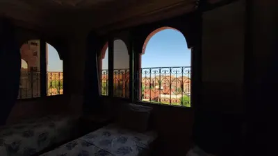 an empty room with three windows with a balcony at Hotel Oasis Tinghir in Tinerhir