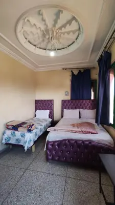 a bedroom with two beds and a ceiling at Hotel Oasis Tinghir in Tinerhir