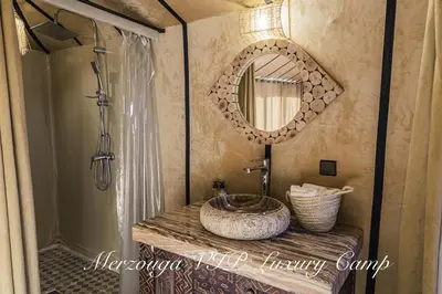 a bathroom with a sink and a mirror at Merzouga VIP Luxury Camp in Merzouga