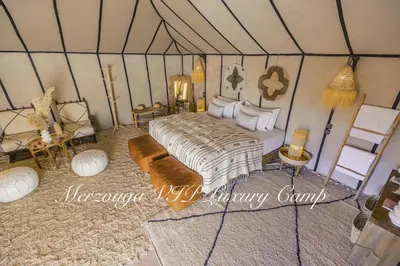 a bedroom with a bed in a tent at Merzouga VIP Luxury Camp in Merzouga