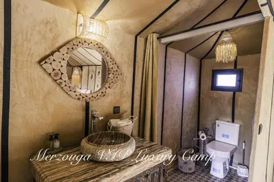a bathroom with a sink and a mirror at Merzouga VIP Luxury Camp in Merzouga
