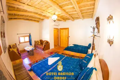 a living room with two beds in a room at Hotel Babylon Dades in Imdiazene