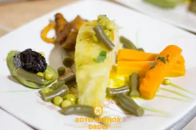 a plate of food with vegetables on it at Hotel Babylon Dades in Imdiazene