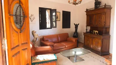 a living room with a leather couch and a table at Extrait d'atlas in Tafza