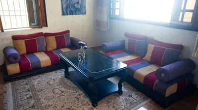 a living room with two couches and a coffee table at Extrait d'atlas in Tafza