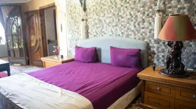 a bedroom with a bed with purple sheets and a lamp at Extrait d'atlas in Tafza