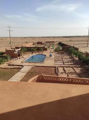 a swimming pool in the middle of the desert at Hotel Kasbah Riad Amnir in Mhamid