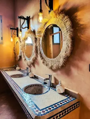 two sinks in a bathroom with two mirrors at Hotel Kasbah Riad Amnir in Mhamid