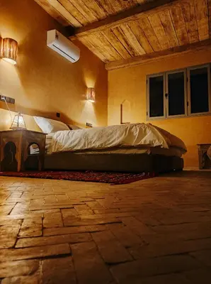 a bedroom with a large bed in a room at Hotel Kasbah Riad Amnir in Mhamid