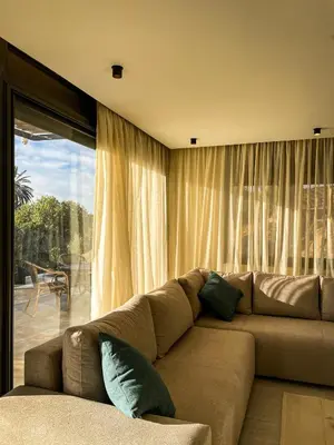 a living room with a couch and a large window at CASA ULIVO villa en pleine nature in Dar Caïd Bou Driss