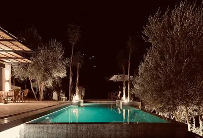 a swimming pool in a backyard at night at CASA ULIVO villa en pleine nature in Dar Caïd Bou Driss