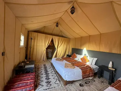 a bedroom with a bed in a tent at hagra luxury camp Merzouga in Merzouga