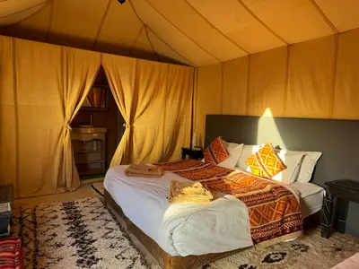 a bedroom with two beds in a tent at hagra luxury camp Merzouga in Merzouga