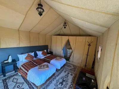 a bedroom with two beds in a tent at hagra luxury camp Merzouga in Merzouga