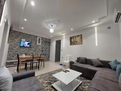 a living room with a couch and a table at New feeling maison climatisée in Ville Nouvelle