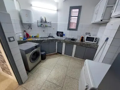 a small kitchen with a washing machine and a microwave at New feeling maison climatisée in Ville Nouvelle
