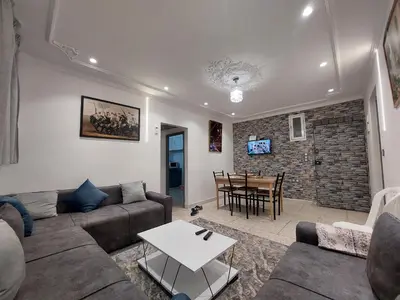 a living room with a couch and a table at New feeling maison climatisée in Ville Nouvelle