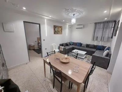 a living room with a table and a couch at New feeling maison climatisée in Ville Nouvelle