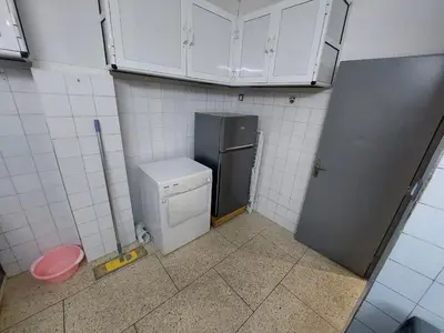 a small kitchen with a refrigerator and white cabinets at New feeling maison climatisée in Ville Nouvelle