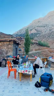 a group of men sitting around a table on a patio at Youssef Rezki Taghia in Taghia