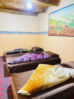a group of three beds in a room at Youssef Rezki Taghia in Taghia