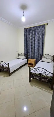 two beds sitting in a room with a window at Diar Kamiliya Meknès in Meknès
