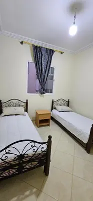 two beds in a room with a window at Diar Kamiliya Meknès in Meknès