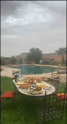 a table with food on it next to a swimming pool at Luxury Villa With Large Private Pool in Marrakech