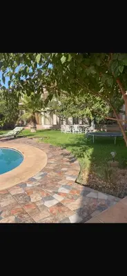 a stone walkway next to a yard with a swimming pool at Luxury Villa With Large Private Pool in Marrakech