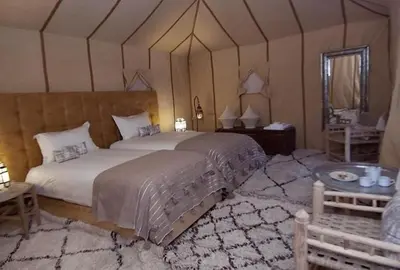 a bedroom with a large bed in a tent at Merzouga Sara Luxury Camp in Merzouga