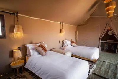 a bedroom with two beds in a tent at Merzouga Sara Luxury Camp in Merzouga