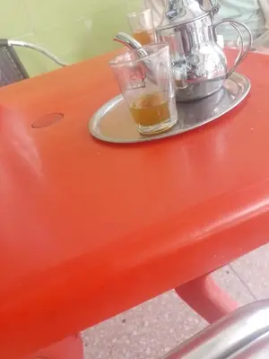 an orange table with a cup of tea on it at Maison youness in Bou Mia