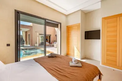 a bedroom with a large bed with a large window at villa Zina, Élégance et luxe,piscine & jacuzzi in Marrakech