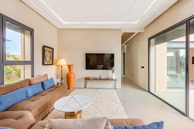 a living room with a couch and a tv at villa Zina, Élégance et luxe,piscine & jacuzzi in Marrakech