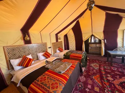 a bedroom with two beds in a tent at Ksar Merzouga in Merzouga