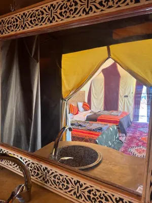 a view of a tent with a table and a sink at Ksar Merzouga in Merzouga