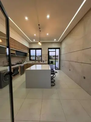 a large kitchen with a table in the middle at Elite Villa on the Road to Fes in Marrakech