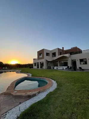 a large house with a swimming pool in front of it at Elite Villa on the Road to Fes in Marrakech