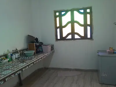 a room with a counter with a window and a table at dar hanane in Zaouia Sidi Rahkal