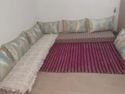 a long couch with a large rug on the floor at dar hanane in Zaouia Sidi Rahkal