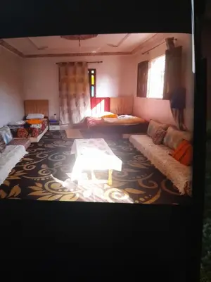 a living room with couches and a table on a carpet at dar hanane in Zaouia Sidi Rahkal